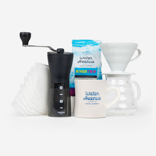 The Water Ave Summer Brewers Bundle. This bundle includes a 12oz bag of River Trip coffee, handheld grinder, diner mug, paper filters, and the Hario V60 brew kit.