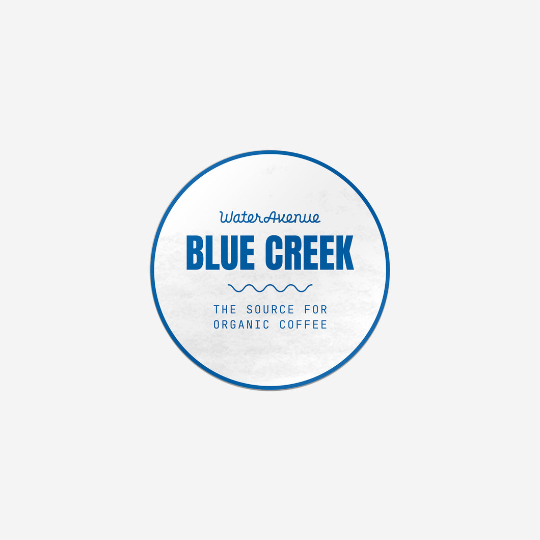 Water Avenue Blue Creek - The Source for Organic Coffee, circular white sticker with blue detailing.