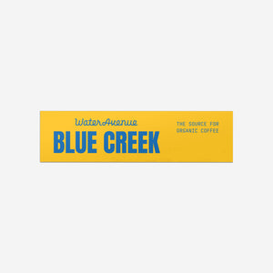 Water Avenue Blue Creek - The Source for Organic Coffee blue and yellow rectangle sticker.