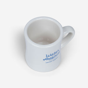 Water Avenue white diner mug with blue logo, shot from above